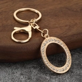 Macro shot of gold-plated metal lobster clasp and keychain with sparkling rhinestones - Letter O