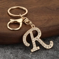 Detailed close-up of golden letter R keychain featuring sparkling inlaid rhinestones - Letter R