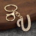 Close-up of golden letter U keychain with sparkling rhinestones and lobster clasp - Letter U