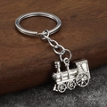 Macro detail of vintage steam locomotive keychain with metallic finish and retro design - Silver (White K)