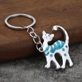 Detail eines süßen Katzen-Schlüsselanhängers mit blauen Streifen und Metallring - Weißes K Silber