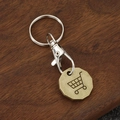 Vintage metal keychain with shopping cart token coin on a dark wooden background - Antique Bronze Polygon