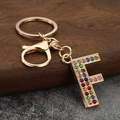 Macro detail of gold letter F keychain with colorful rhinestones and lobster clasp - Letter F