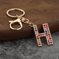 Detail of letter H keychain featuring colorful rhinestones and gold lobster clasp - Letter H