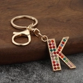 Macro view of crystal encrusted letter K keychain with colorful rhinestones on gold metal - Letter K