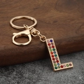 Detailed macro view of the gold-toned letter L keychain encrusted with colorful rhinestones - Letter L