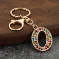 Detailed view of luxury gold-tone letter O keychain with vibrant colorful rhinestones - Letter O