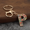 Detailed close-up of a golden metal letter P keychain with colorful rhinestones - Letter P