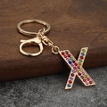 Detail of letter X keychain featuring colorful rhinestones and gold lobster clasp - Letter X