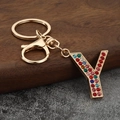 Macro shot of letter Y keychain with colorful rhinestones on a gold-plated alloy base - Letter Y