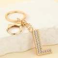 Close-up of golden metal letter L keychain with sparkling rhinestones and lobster clasp - Letter L
