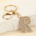 Detailed view of golden letter R keychain with sparkling white rhinestones and clasp - Letter R