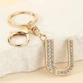 Macro detail of gold letter U keychain with sparkling rhinestones and lobster clasp - Letter U