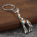 Portachiavi giraffa in smalto colorato in lega di zinco su sfondo rustico in legno - Argento