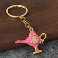 Macro detail of pink enamel Aladdin lamp keychain with gold plating and rhinestones - Gold + Pink