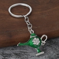 Vista macro de llavero de lámpara de Aladino en esmalte verde con adornos de cristal fino - Plata & Verde