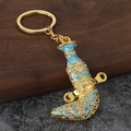 Close-up of golden Omani Jambiya keychain with blue enamel inlay and white rhinestones - Sky Blue