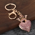 Macro-opname van goudkleurige hart-kroon sleutelhanger met roze strass-steentjes - Kroon Roze Strass