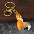 Dettaglio portachiavi a forma di volpe smaltata con strass bianchi e chiusura dorata - Oro Antico Arancione
