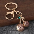 Macro detail van paarse stras kers sleutelhanger met gouden legering karabijnsluiting - Paars