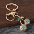 Detail of sparkling blue rhinestone cherry keychain with golden frame and emerald leaf - Sky Blue
