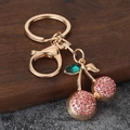 Detail of gold cherry keychain with pink rhinestones and green crystal leaf charm - Rose Red