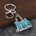 Detailed macro view of silver alloy handbag keychain with bright blue rhinestones - Silver/Blue Zirconia