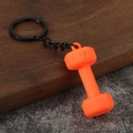 Creative orange dumbbell keychain with 45 LB weight detail on dark wooden surface - Orange