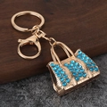 Detail view of golden handbag keychain with sparkling blue rhinestones and lobster clasp - Gold Plated Blue Zirconia