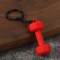 Macro detail of red 45 LB dumbbell keychain with matte finish on textured background - Red