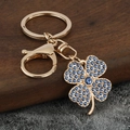 Dettaglio del portachiavi a quadrifoglio dorato con cristalli blu e chiusura a scatto - Zirconia Blu