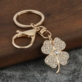 Détail d'un porte-clés trèfle doré étincelant orné de cristaux et de diamants micro-pavés - Zircone Blanche