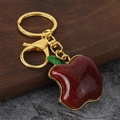 Portachiavi a mela rossa glitterata con foglia verde e chiusura dorata su sfondo materico - Mela Rossa Chiusura Dorata (Imitazione Oro) / Oro