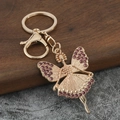 Llavero de bailarina dorada con diamantes de imitación morados y alas de mariposa - Diamante de Imitación Rosa Rojo