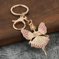 Detalle del llavero de hada dorada con diamantes de imitación rosas y alas finas - Rosa Diamante