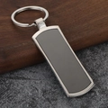 Sublimation metal bottle opener keychain with rectangular inlay on a modern wood surface - Long Oval