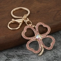 Golden clover keychain with pink crystals and shimmering center stone on marble - Pink Rhinestone