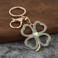 Detail of four-leaf clover keychain with blue rhinestones and iridescent central crystal - Blue Rhinestone