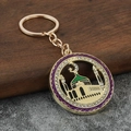 Detail of a gold mosque keychain with purple rim and rhinestones on a wooden background - Purple
