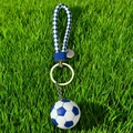 Portachiavi da calcio intrecciato blu e bianco su erba, accessorio sportivo 2026 - Calcio Blu con Cordino Intrecciato