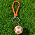 Dettaglio del portachiavi a pallone da calcio con cinturino in pelle intrecciata arancione - Calcio Arancione con Cordino Intrecciato
