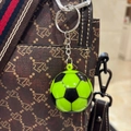 Détail d'un porte-clés ballon de foot vert fluo attaché à un sac à main à motifs marrons - 3.8CM / Vert