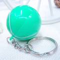 Close-up of a light green tennis ball keychain with silver metal ring on white grid fabric - 3.2cm / Tennis Ball