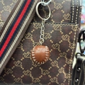 Detail van een bruine leren honkbal sleutelhanger met witte stiksels aan een tas - 2.7cm / Bruin