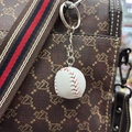 Detail of white baseball keychain with red stitching hanging on a printed leather bag - 2cm / White