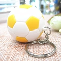 Dettaglio di un mini portachiavi a pallone da calcio giallo e bianco su tessuto intrecciato - Calcio Giallo