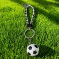 Braided leather football keychain with realistic soccer ball pendant on green grass - Classic Football with Braided Strap