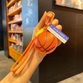 Détail du porte-clés basket en cuir PU orange avec texture cousue et cordon tressé - Basketball