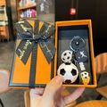 Dettaglio del portachiavi a tema calcio in una confezione regalo arancione vivace - Calcio Bianco e Nero + Confezione Regalo