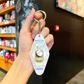 Macro detail of a white diamond-shaped golf keychain featuring retro sports graphics - White Sports - Golf